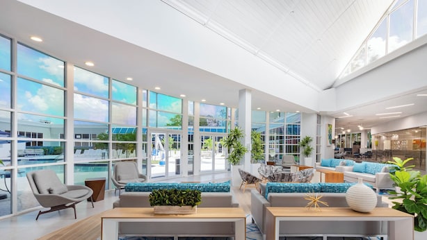 A spacious lobby with large windows, a pool view, and modern seating areas. - Holiday Inn Resort Kissimmee by the Parks by IHG (Kissimmee)