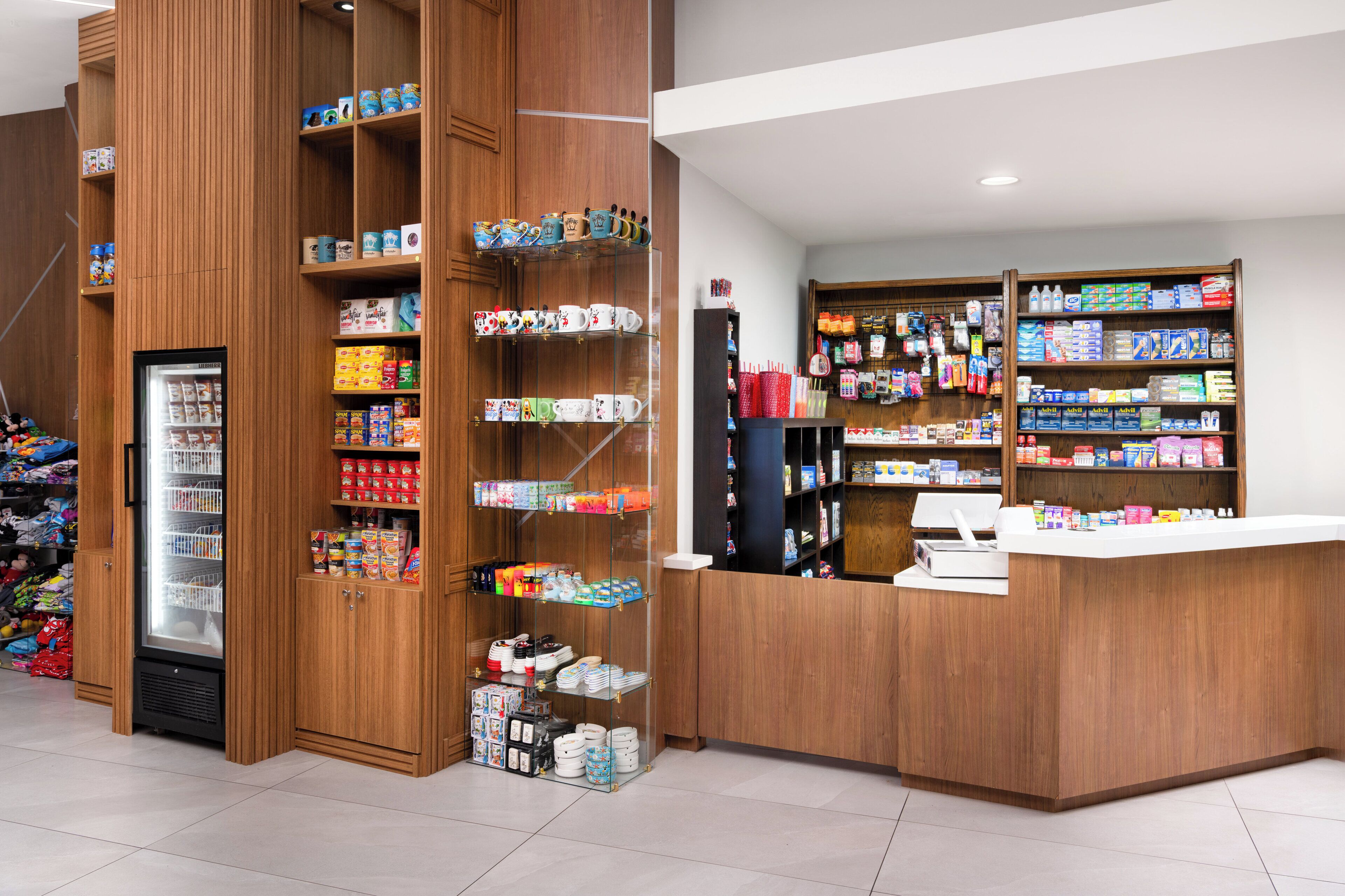 Una farmacia con estantes de madera llenos de diversos productos para la salud y una sección refrigerada.