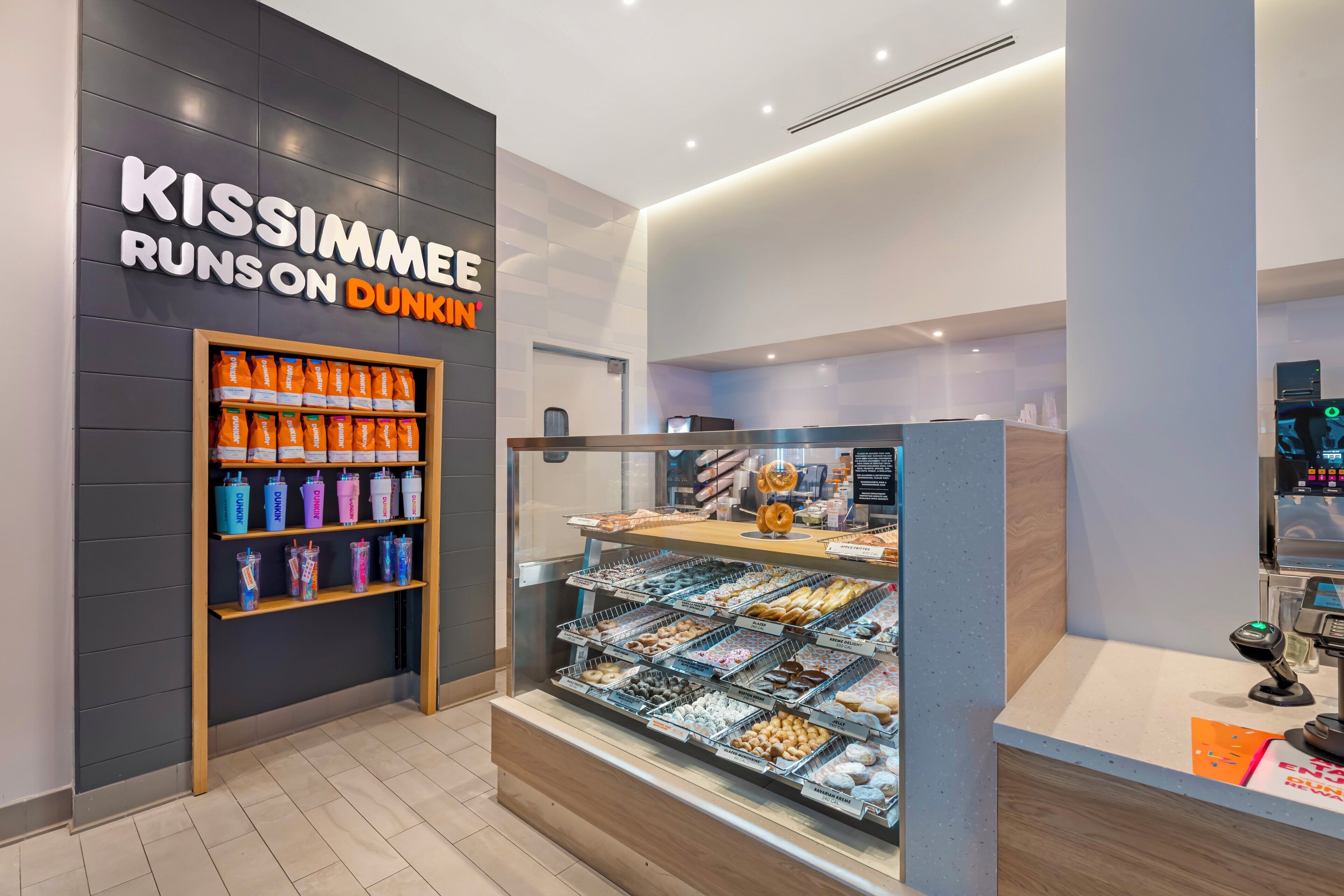 En Dunkin' Donuts-kiosk med ett utbud av drycker och bakverk.