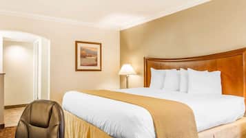 Une chambre d’hôtel avec un grand lit, un bureau et une chaise.
