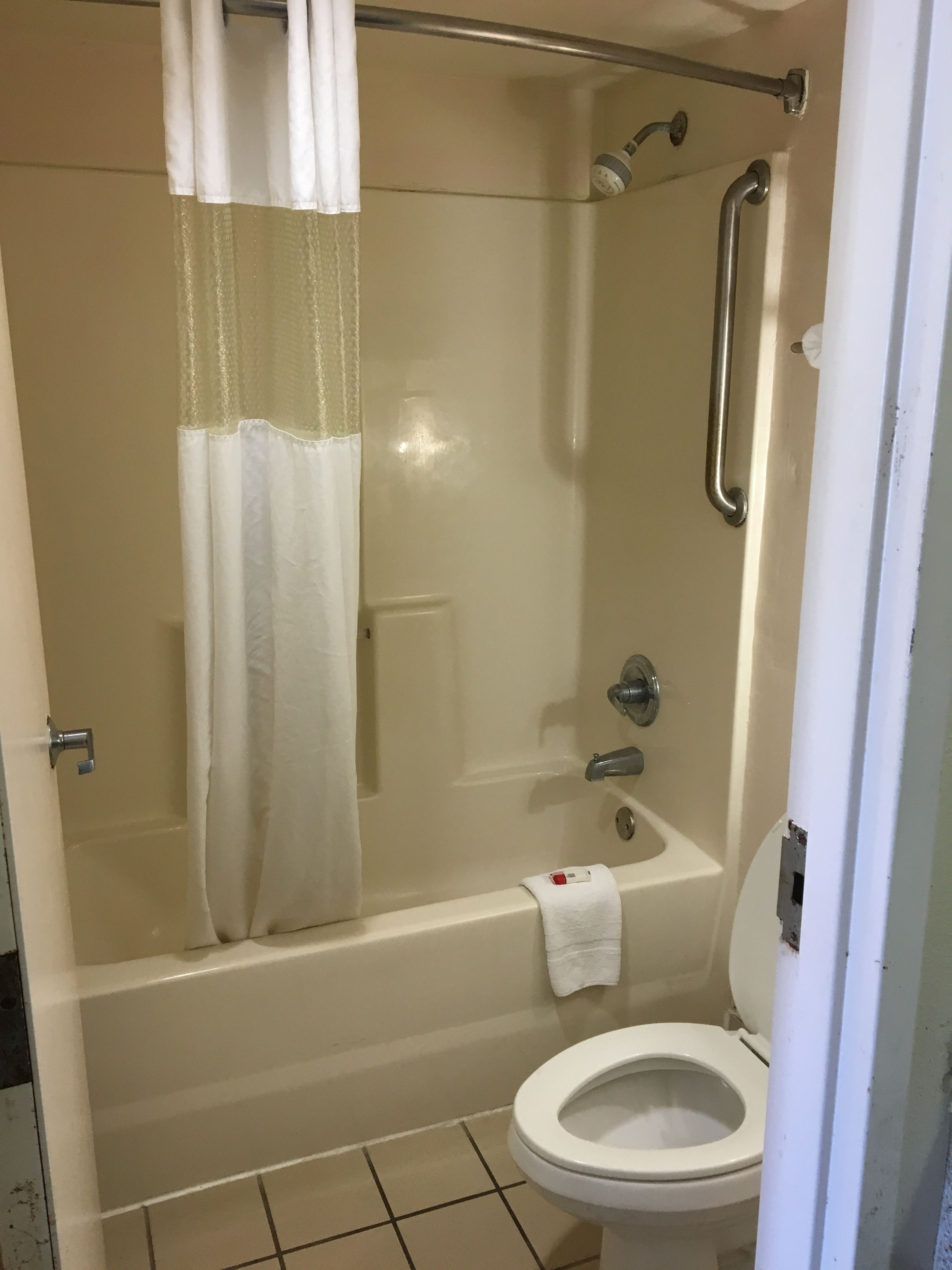A bathroom with a bathtub, a toilet, and a shower area.