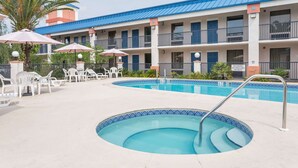 A hotel with a pool area, outdoor seating, and a sign indicating no lifeguard on duty. - Days Inn by Wyndham Chiefland (Chiefland)