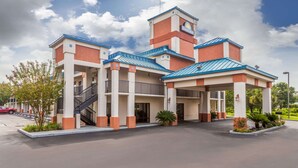 A Days Inn with a central tower, multiple balconies, and a covered entrance area. - Days Inn by Wyndham Chiefland (Chiefland)