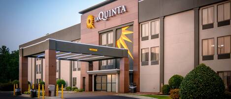 A La Quinta hotel with a modern facade, a covered entrance, and well-maintained landscaping.