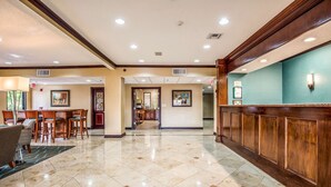A hotel lobby with a reception desk, seating area, and a hallway leading to other rooms. - Quality Inn & Suites Seabrook - NASA - Kemah (Seabrook)