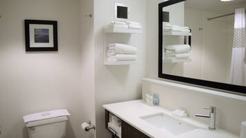 A bathroom with a toilet, sink, and towel racks.