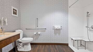 Un baño moderno con inodoro, lavamanos y zona de ducha.