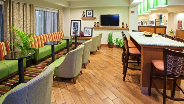 Un hall de hotel con una zona de estar, un bar y un televisor.