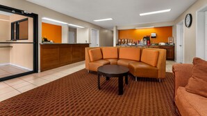 A hotel lobby with a sectional sofa, a coffee station, and a reception desk. - Americas Best Value Inn Montezuma (Montezuma)