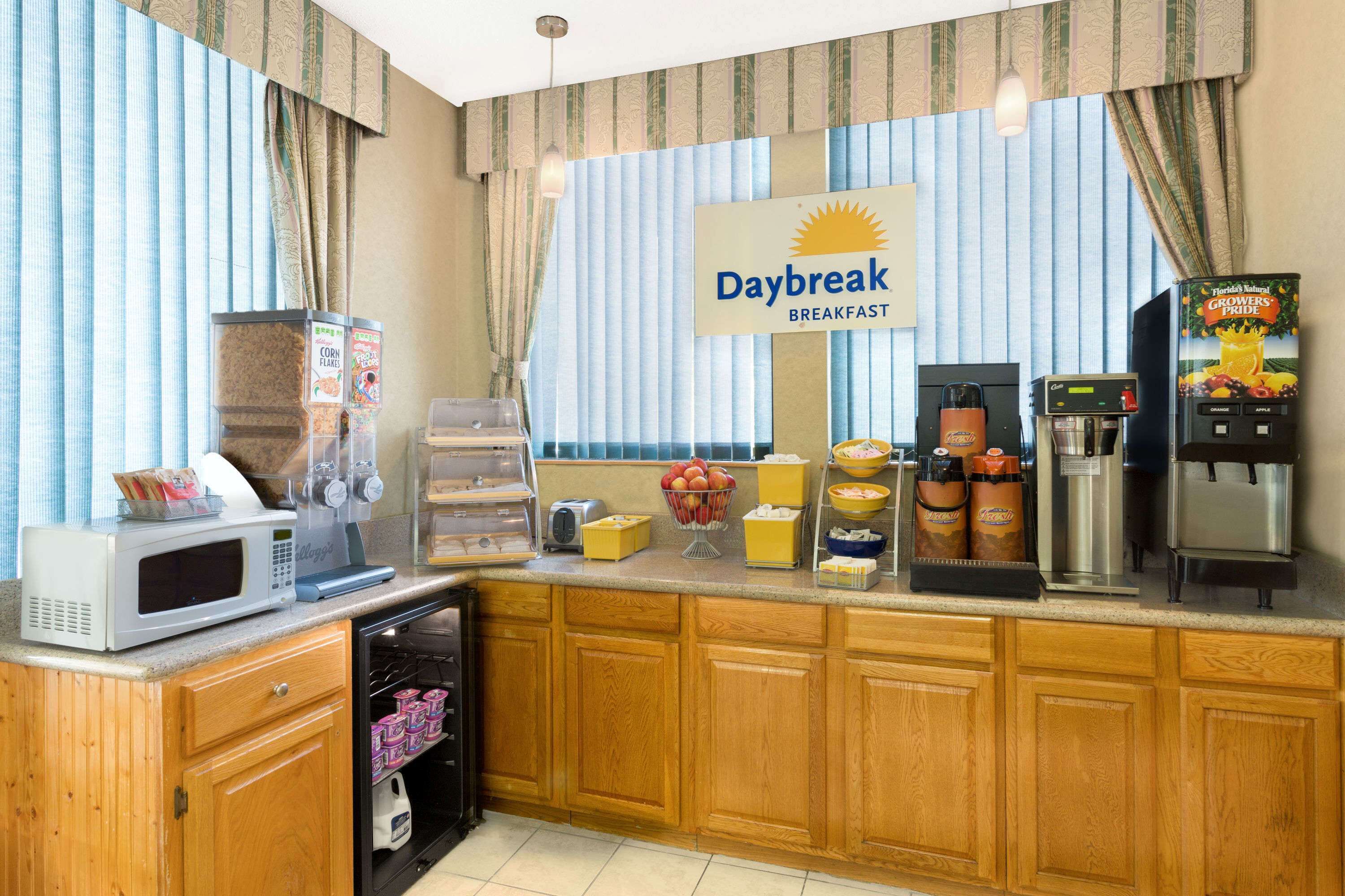 Un comedor con microondas, cafetera y un letrero que dice "Daybreak Breakfast".