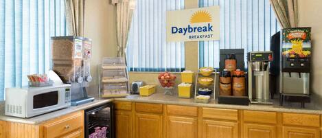 Un comedor con microondas, cafetera y un letrero que dice "Daybreak Breakfast".