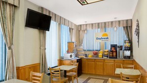 A breakfast area with a TV, a coffee machine, and a sign that says "Daybreak Breakfast". - Days Inn by Wyndham Biscoe (Biscoe)