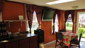 A compact kitchen with a refrigerator, a microwave, and a small dining table with chairs.