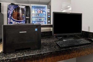 Una impresora Samsung y un monitor Lenovo sobre una encimera de granito negro.