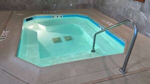 Tinaco rectangular con escalera metálica, rodeado de piso de baldosas.