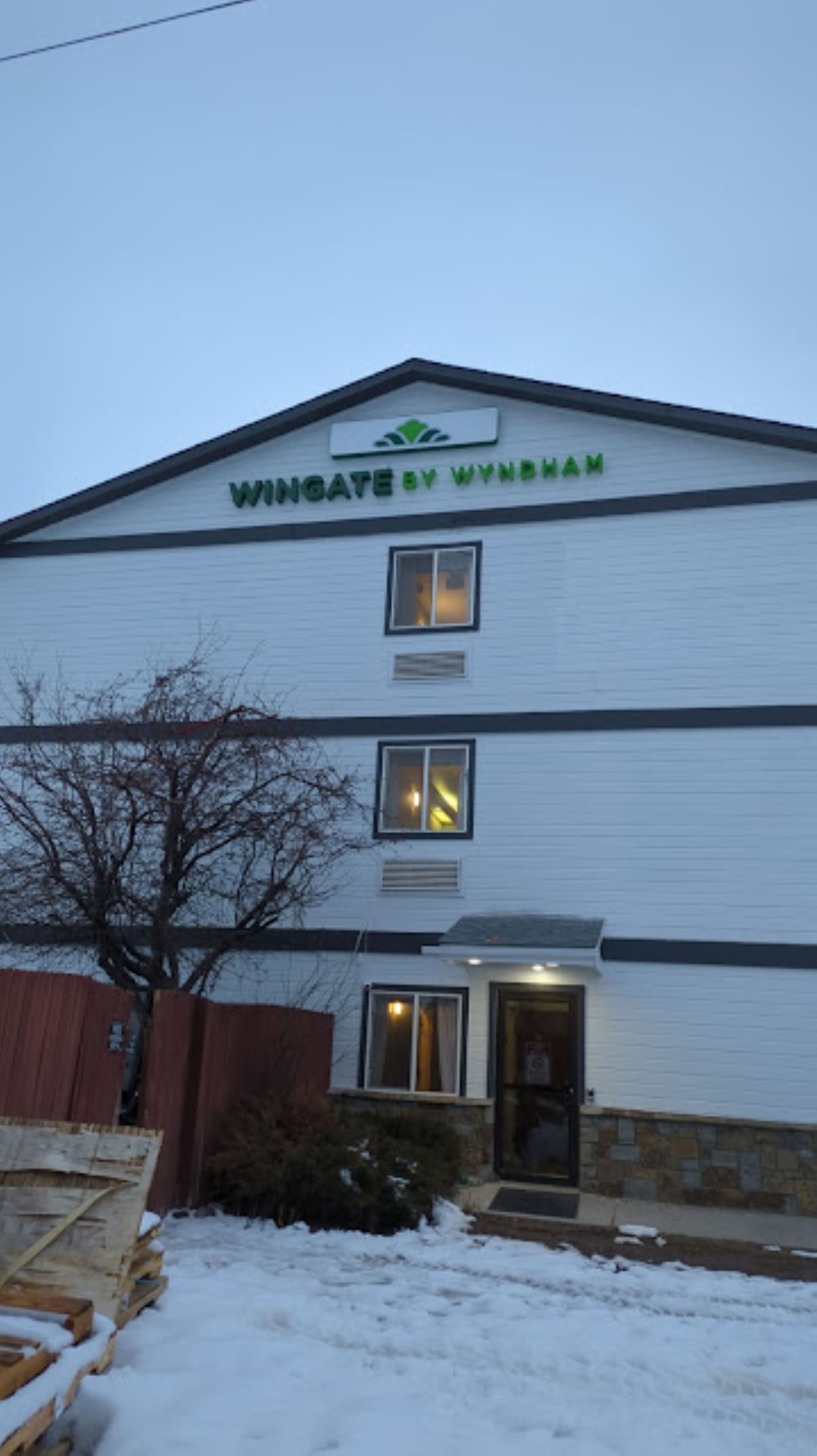 En toetagers bygning med et skilt, der viser "Wingate by Wyndham" på taget.