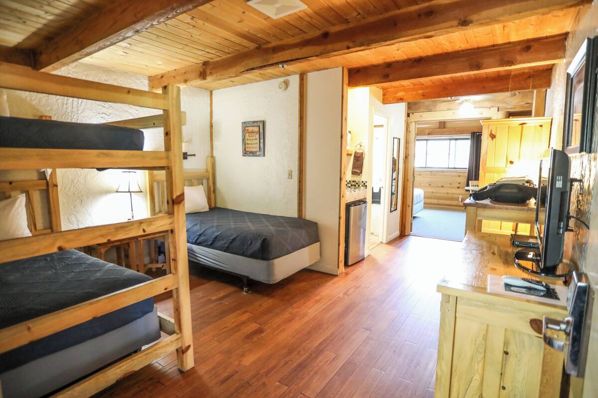 A cabin with bunk beds, a kitchenette, and a bathroom.