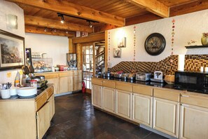 A kitchen with wooden cabinets, a clock, and a tiled backsplash. - The Boulder Creek Lodge (Nederland)