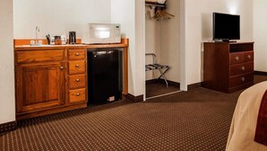 A hotel room with a kitchenette, a microwave, a refrigerator, a TV, and a wardrobe. - Quality Inn Kingdom City I-70 (Kingdom City)