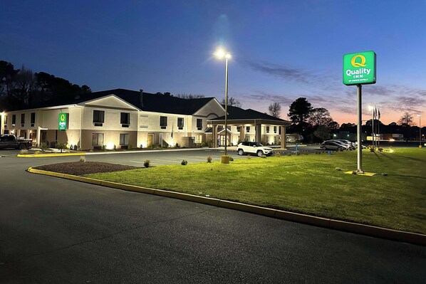 A Quality Inn by Choice Hotel with a well-lit entrance, a parking lot, and a grassy area in front. - Quality Inn & Suites Exmore - Eastern Shore (Exmore)