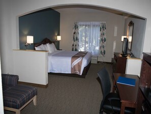 A hotel room with a bed, two bedside lamps, a desk with a computer, a chair, and a window with curtains. - Quality Inn & Suites Exmore - Eastern Shore (Exmore)
