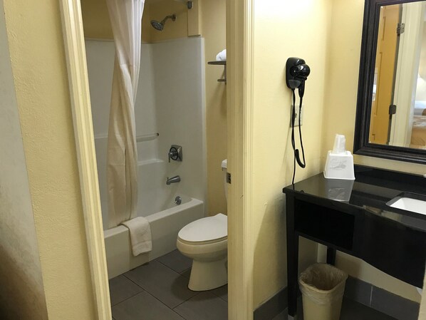 Une salle de bain avec une baignoire, des toilettes et un lavabo avec un miroir.
