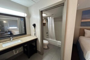 Een badkamer met wastafel, spiegel, toilet en douchehoek.