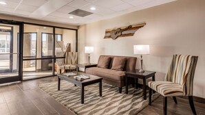 A modern living room with a sofa, armchairs, a coffee table, and a rug. - Quality Inn Gordonsville (Gordonsville)