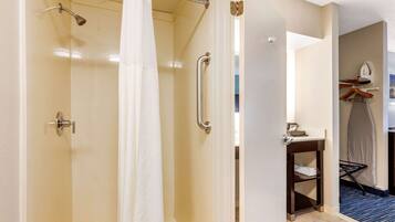 A hotel bathroom with a shower, a toilet, and a sink.
