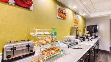 A breakfast bar with a toaster, muffin display, coffee maker, and waffle display.