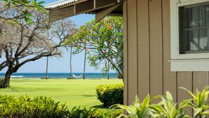 A view of a beach with a hammock, palm trees, and a building with a window. - Waimea Plantation Cottages, a Coast Resort (Waimea)