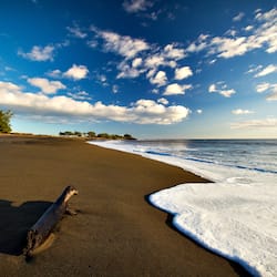 On the beach, black sand, beach umbrellas, beach towels