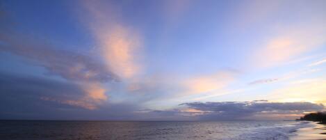 A beach with a calm sea and a clear sky.