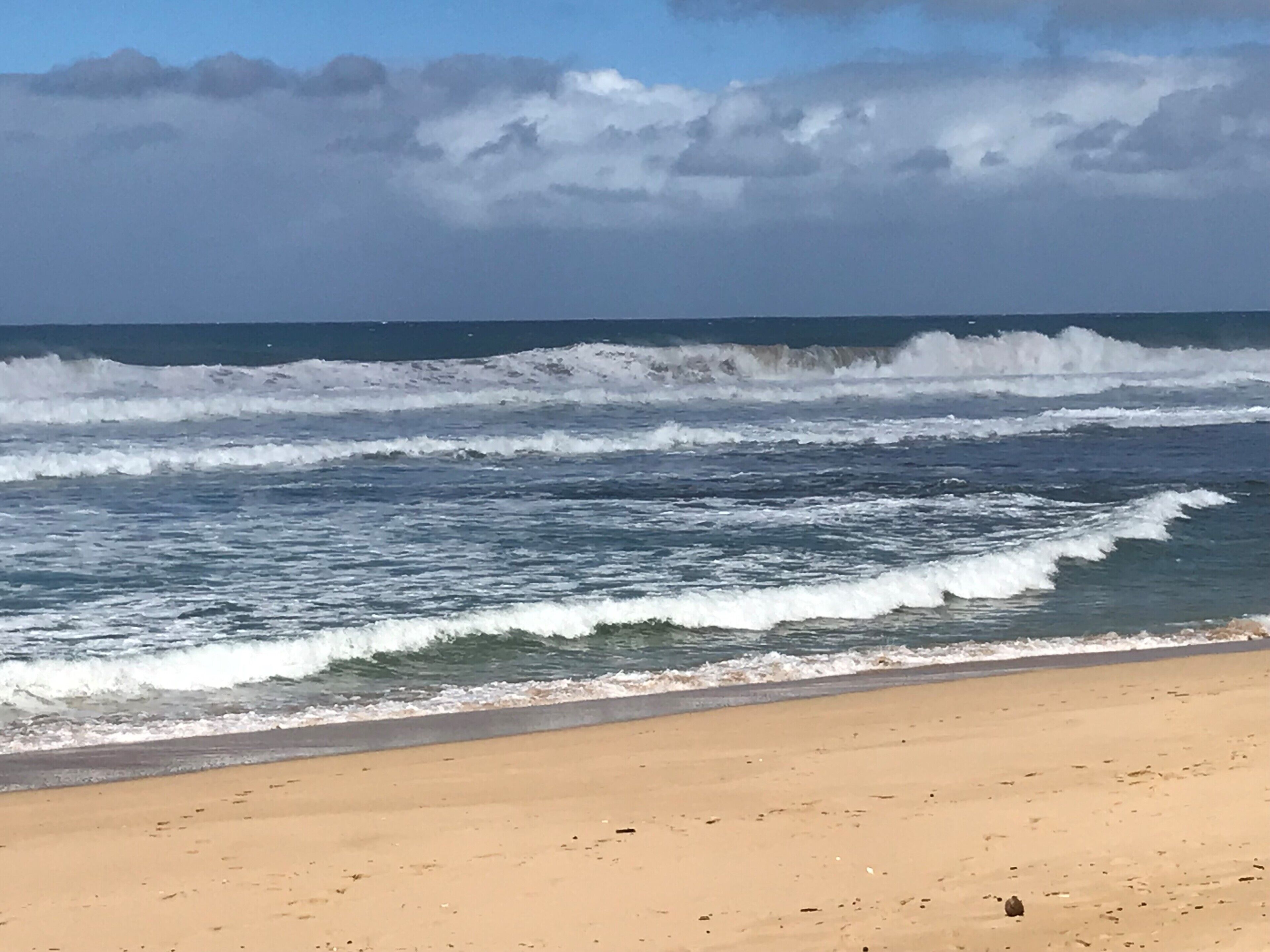 Une plage avec des vagues et un ciel dégagé.
