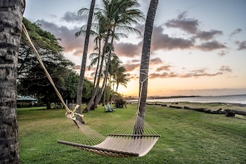 On the beach, black sand, beach umbrellas, beach towels at Waimea Plantation Cottages, a Coast Resort