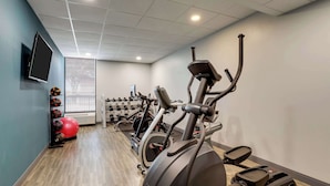 A gym with exercise equipment, a TV, and dumbbells. - Hampton Inn Lebanon (Lebanon)