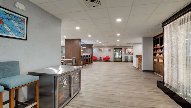 A modern lobby with a reception desk, seating area, and a decorative wall with a map. - Hampton Inn Lebanon (Lebanon)