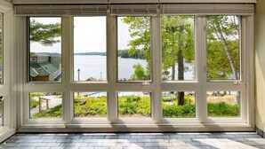A room with large windows overlooking a lake and greenery. - Rocky Crest Golf Resort (Seguin)
