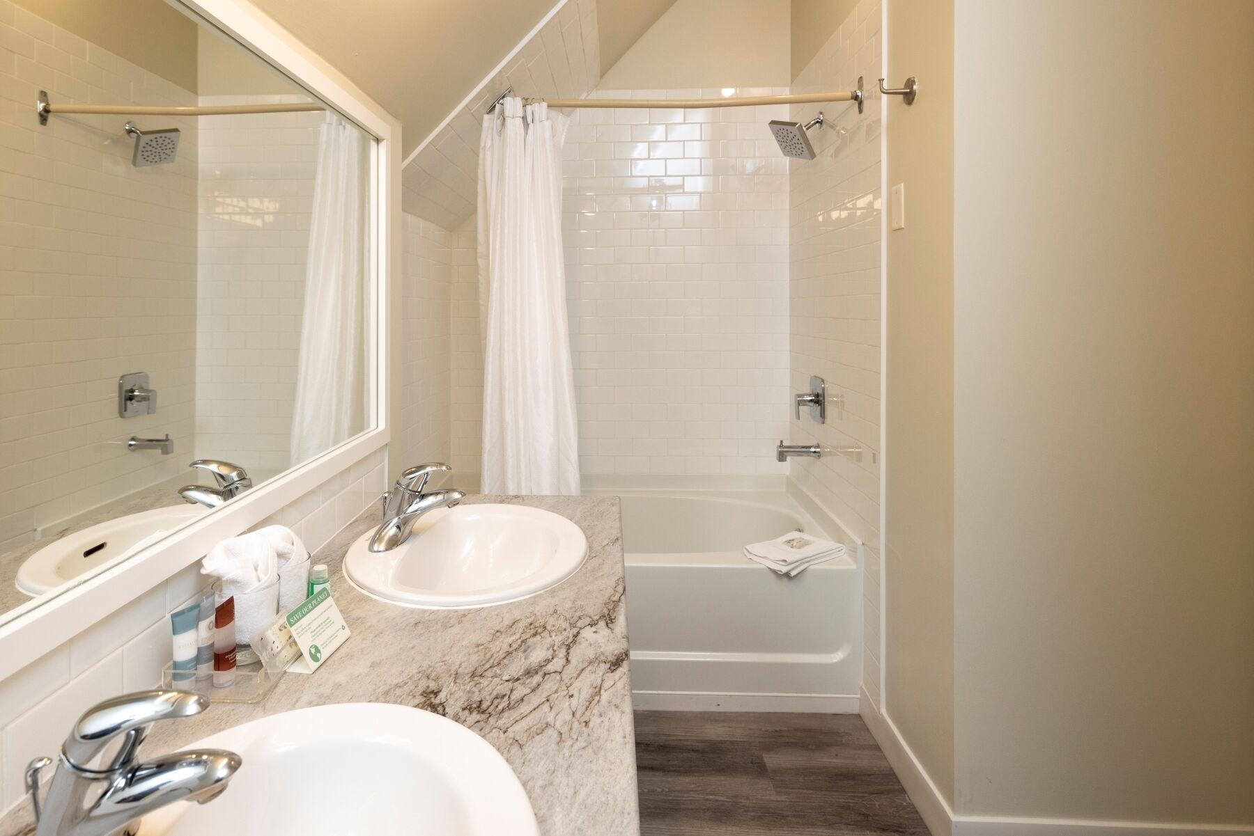 Une salle de bain avec deux lavabos, une baignoire et une douche.