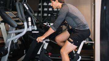 Une salle de sport équipée de tapis de course et d’appareils d’exercice.