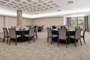 A conference room with round tables, chairs, and a stone pillar. - Quality Inn and Conference Centre (Pembroke)