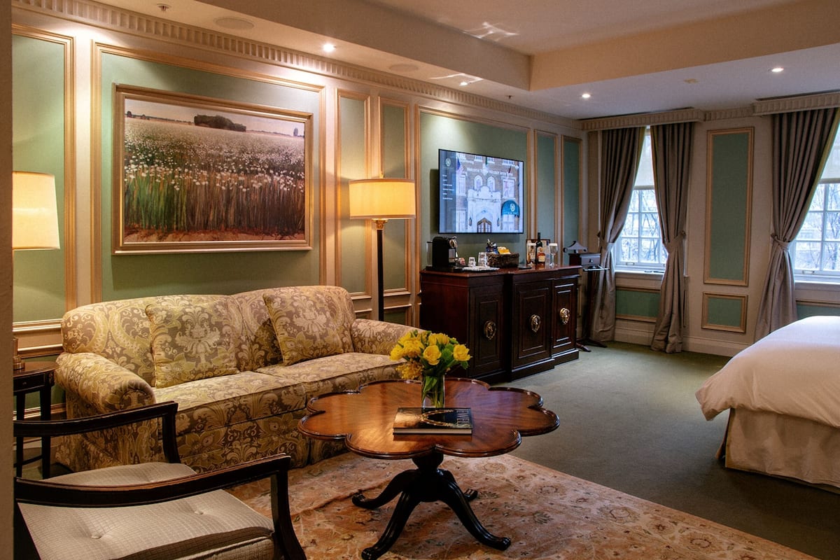 Une chambre d’hôtel équipée d’un canapé, d’une table basse, d’une télévision, d’une commode et d’un lit.