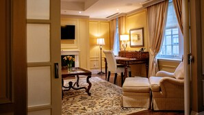 Une chambre d’hôtel comprenant un coin repas, un canapé, une lampe et une cheminée.