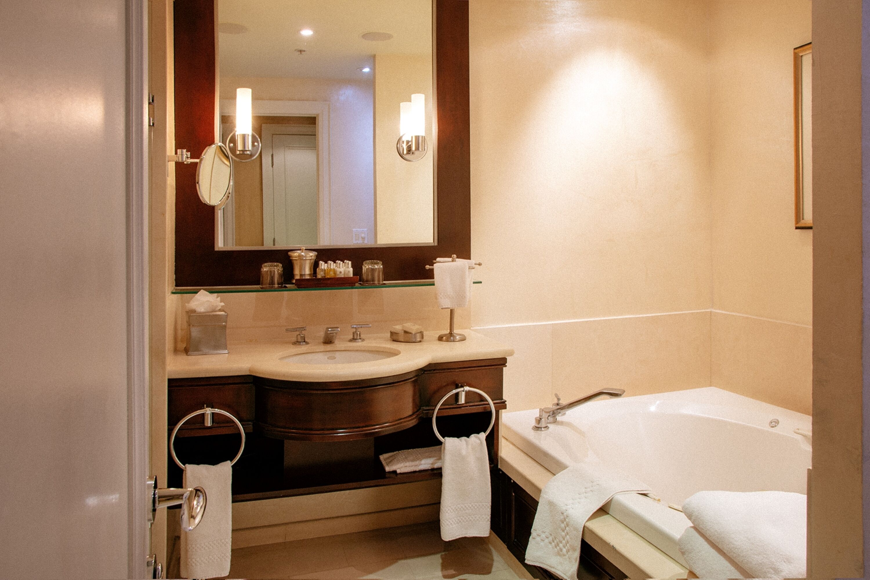 A modern bathroom with a double sink vanity, a large mirror, and a standalone bathtub.