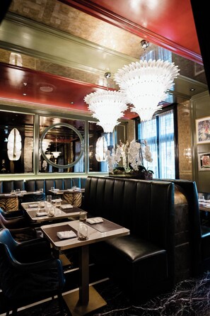 A restaurant interior with booths, tables, and a decorative chandelier. - Windsor Arms Hotel (Toronto)