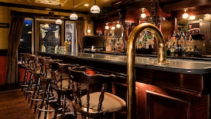 A bar area with wooden chairs, a bar counter, and a variety of bottles. - Inn on the Lake (Fall River)