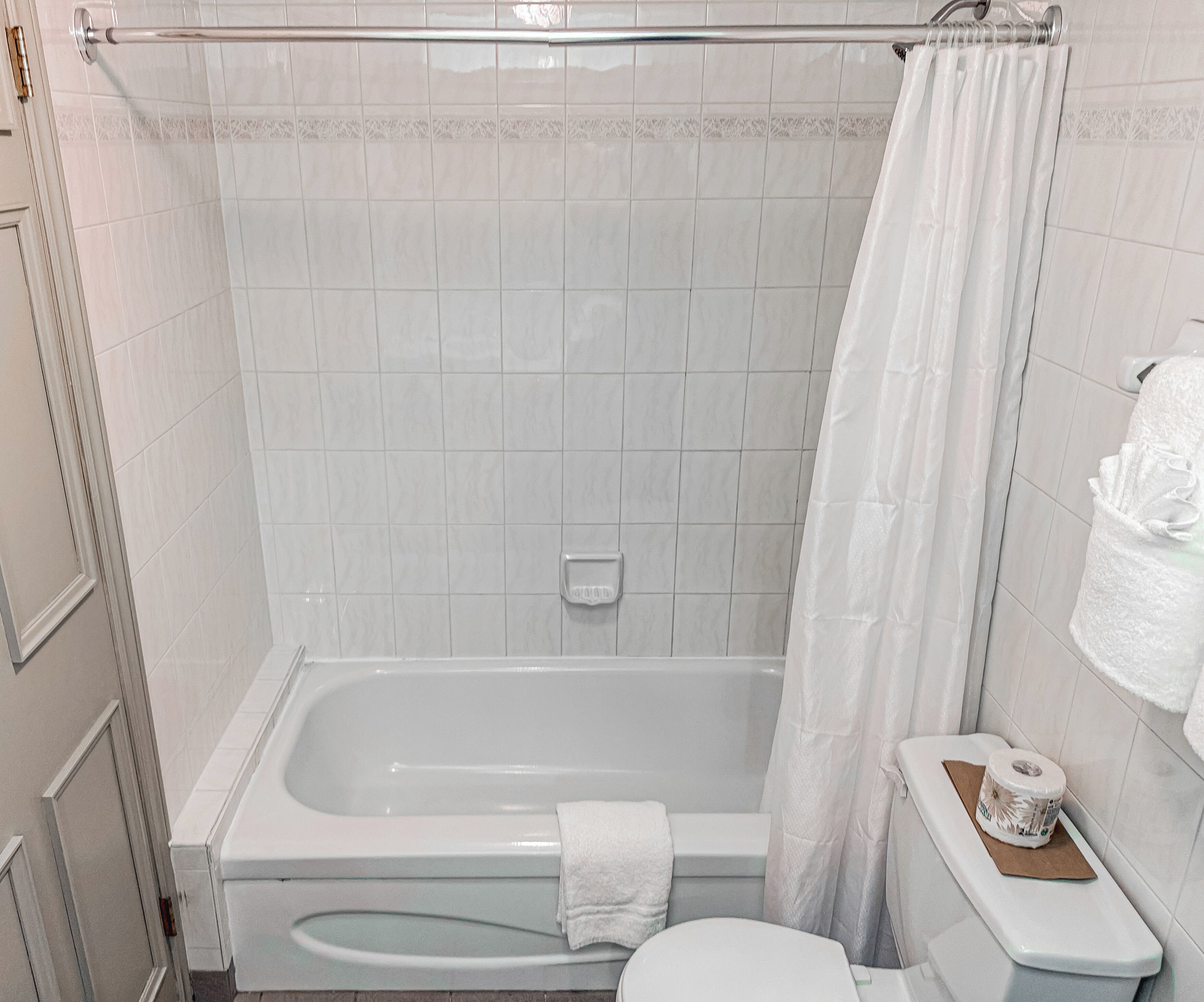 Un baño con bañera, inodoro y cortina de ducha.