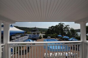 A covered outdoor area with a pool, lounge chairs, and a gazebo.