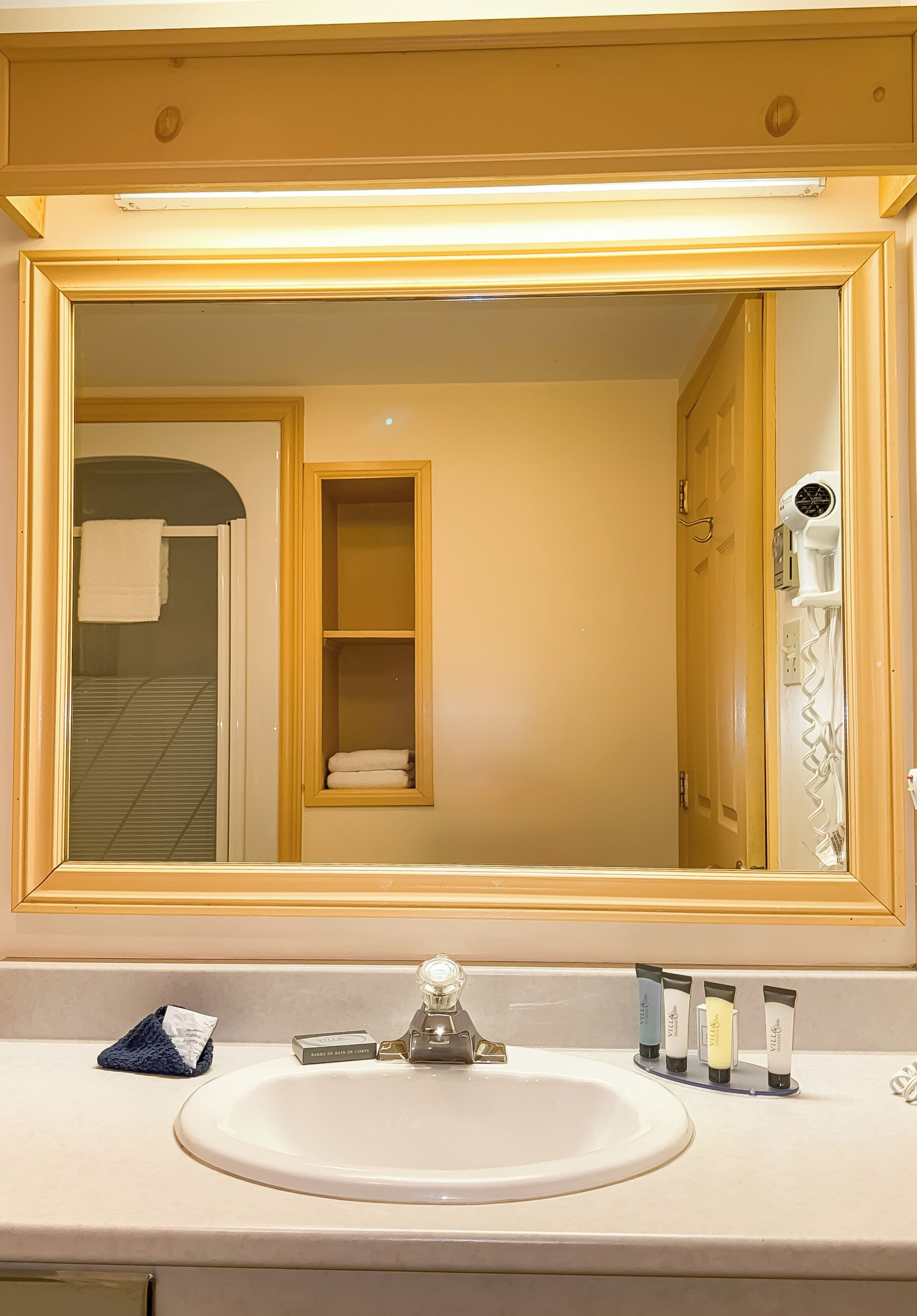 Une salle de bain équipée d’un lavabo, d’un miroir et d’articles de toilette.