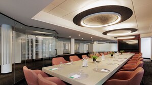 A conference room with a long table, chairs, and a large screen. - Hôtel Alt Québec (Québec City)